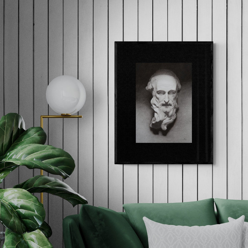 Framed artwork of a bust on a wall with a green sofa and plant in the foreground.