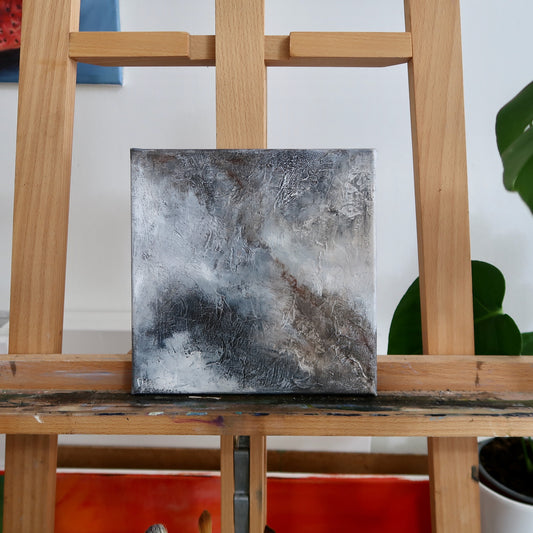 Abstract acrylic landscape painting displayed on a wooden easel.